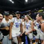 UCLA players celebrate their 2026 Elite Eight win in a huddle.
