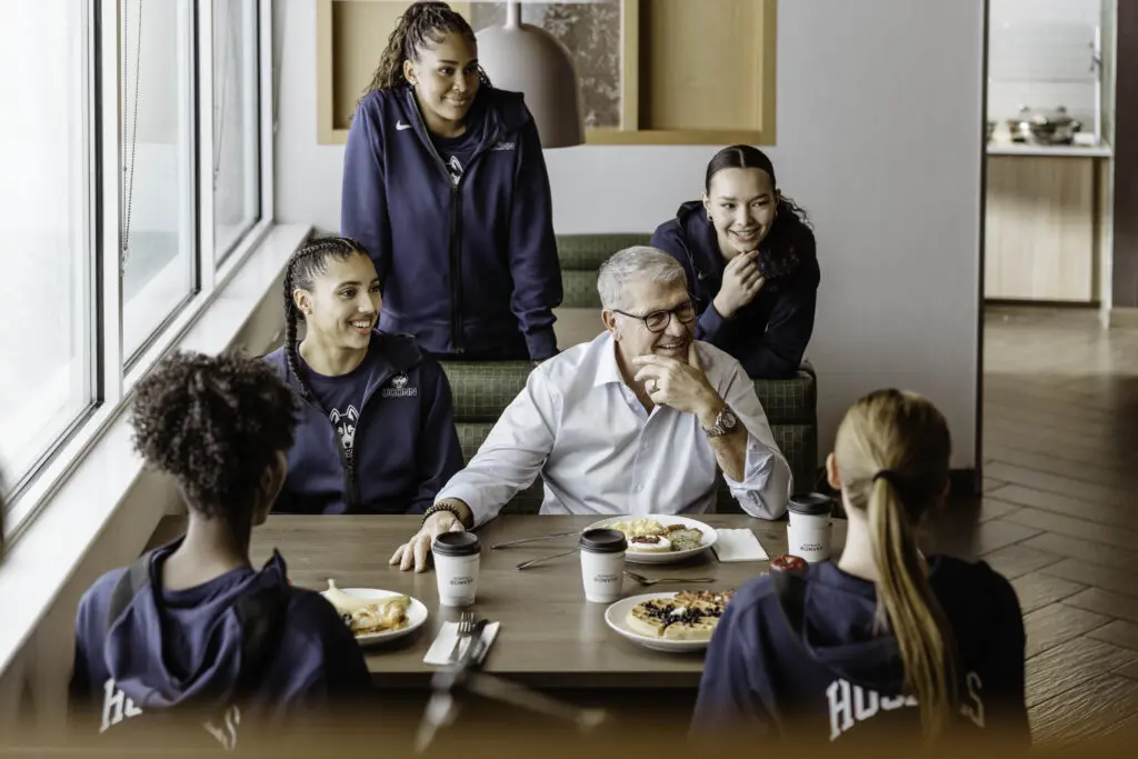 Azzi Fudd sits at a table with the UConn women's basketball team inside a Marriott Bonvoy hotel ahead of Women's March Madness.