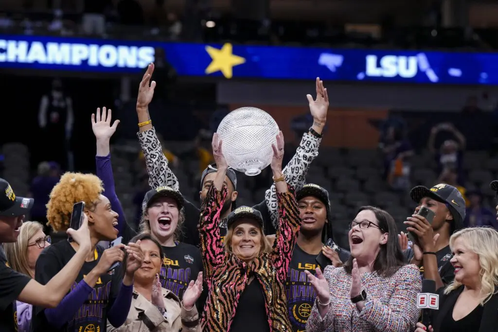 March Madness LSU Lady Tigers head coach Kim Mulkey celebrates with a trophy after defeating the Iowa Hawkeyes during the final round of the Women's Final Four NCAA tournament at the American Airlines Center. 