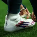 NWSL brands detail as Trinity Rodman #2 of Washington Spirit ties back her boot during the NWSL match between Washington Spirit and Portland Thorns FC at Audi Field on March 13, 2026 in Washington, DC.