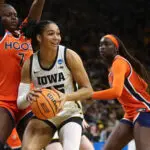 Forward Hannah Stuelke #45 of the Iowa Hawkeyes goes to the basket in the second half against forward Tabitha Amanze #7 and forward Adeang Ring #8 of the Virginia Cavaliers on March 23, 2026 at Carver-Hawkeye Arena during the second round of the NCAA Women's Basketball Tournament, in Iowa City, Iowa.