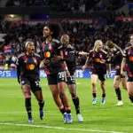 UWCL semifinals star Lily Yohannes of OL Lyonnes celebrates scoring her team's first goal with teammates Ashley Lawrence and Kadidiatou Diani during the UEFA Women's Champions League 2025/26 Quarter-finals Second Leg match between OL Lyonnes and VfL Wolfsburg at OL Stadium on April 02, 2026 in Decines-Charpieu, France.
