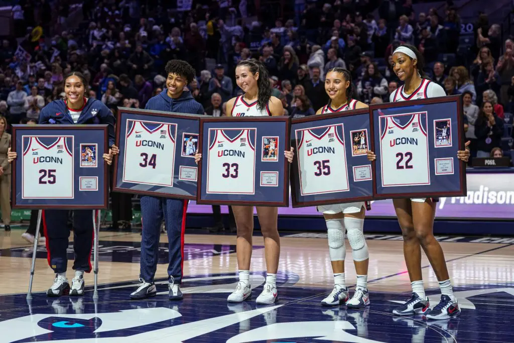 UConn women's basketball forward Ice Brady (25), forward Ayanna Patterson (34), guard Caroline Ducharme (33), guard Azzi Fudd (35) and forward Serah Williams (22) hold up their jerseys during senior night after defeating the Providence Friars at Harry A. Gampel Pavilion.