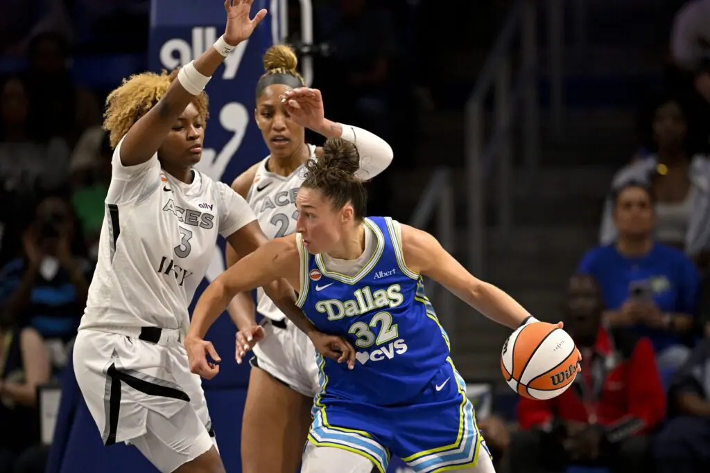 Dallas Wings forward Jessica Shepard (32) looks to move the ball past Las Vegas Aces forward Nalyssa Smith (3) and center A'ja Wilson (22) during the second half of the Aces vs Wings WNBA game at College Park Center.