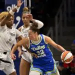 Dallas Wings forward Jessica Shepard (32) looks to move the ball past Las Vegas Aces forward Nalyssa Smith (3) and center A'ja Wilson (22) during the second half of the Aces vs Wings WNBA game at College Park Center.