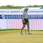 Maja Stark lines up a shot at the 18th green during the final round of the U.S. Women's Open golf tournament in front of the LPGA leaderboard featuring Nelly Korda.