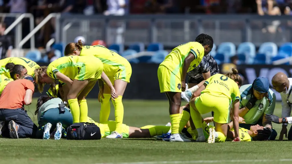 Washington Spirit defender Tara Rudd (9) and Washington Spirit defender Lucia di Guglielmo (13) on the ground after colliding on an attempt to head the ball during the first half at PayPal Park.