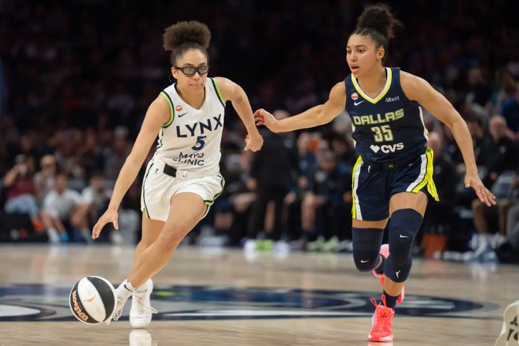 Minnesota Lynx guard Olivia Miles (5) drives by the defense of Dallas Wings guard Azzi Fudd (35) in the third quarter at Target Center.