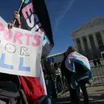 LGBTQ+ rights advocates rally outside the US Supreme Court as justices hear arguments in challenges to state bans on transgender athletes in women's sports on January 13, 2026, in Washington, DC. The US Supreme Court on January 13 wades into the hot-button issue of transgender athletes in girls' and women's sports. The conservative-dominated court is to hear challenges to state laws in Idaho and West Virginia banning transgender athletes from female competition. More than two dozen US states have passed laws in recent years barring athletes who were assigned as male at birth from taking part in girls' or women's sports.