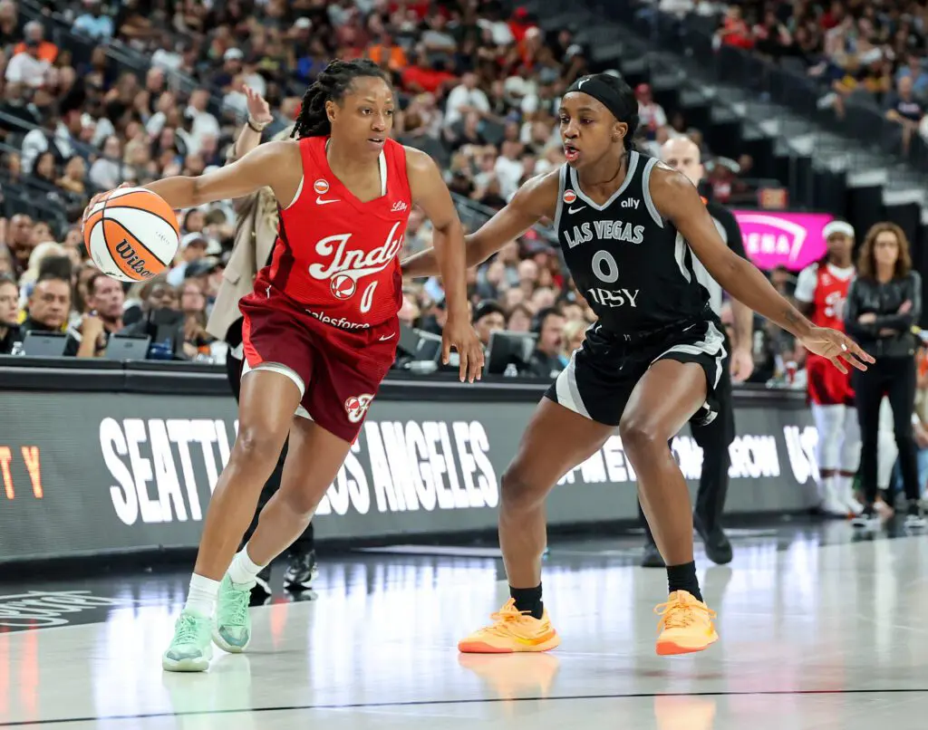 Kelsey Mitchell of the Indiana Fever drives against Jackie Young #0 of the Las Vegas Aces in the third quarter of their game at T-Mobile Arena.
