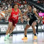 Kelsey Mitchell of the Indiana Fever drives against Jackie Young #0 of the Las Vegas Aces in the third quarter of their game at T-Mobile Arena.
