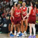 Kelsey Mitchell #0 of the Indiana Fever celebrates after making a basket and drawing a foul with teammates Sophie Cunningham #8, Caitlin Clark #22 and Monique Billings #25 during the second half against the Seattle Storm at Climate Pledge Arena.