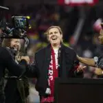 Retired Portland Thorns FC player women's soccer great Christine Sinclair receives a coat from former GM Karina LeBlanc, right, during a ceremony in her honor as she is inducted into the Thorns Hall of Fame at Providence Park.