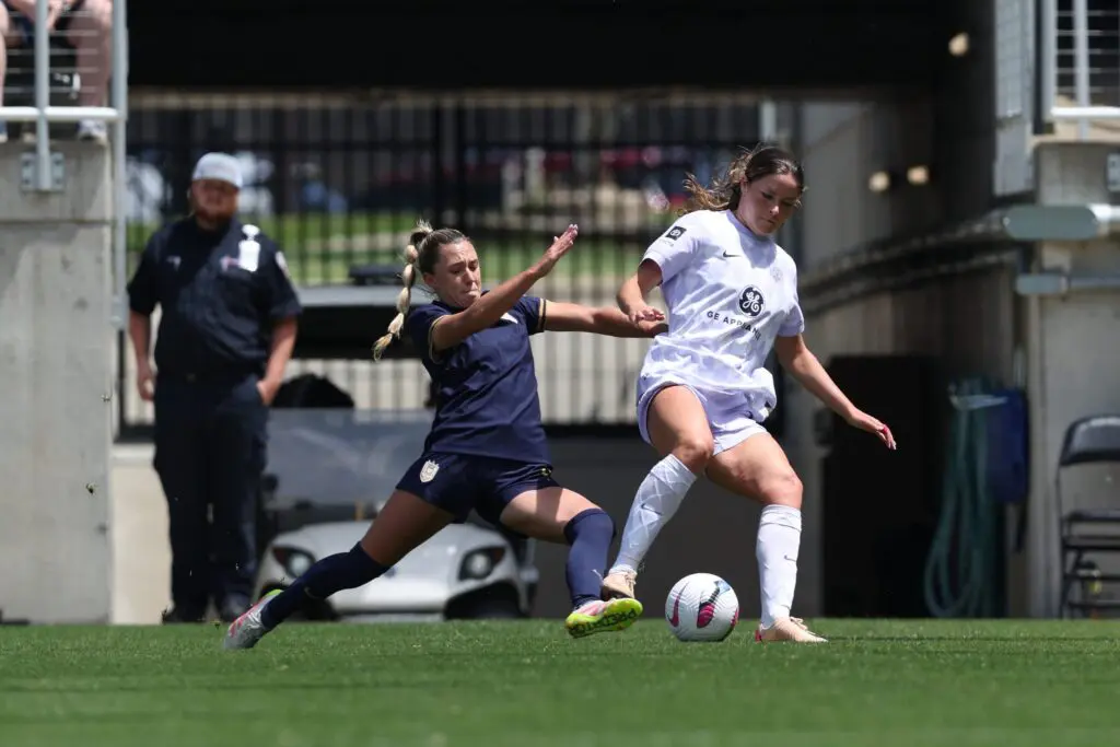 Seattle Reign FC midfielder Ainsley McCammon (left) and Racing Louisville FC forward Emma Sears (right) fight for possession of the ball during the second half at Lynn Family Stadium.
