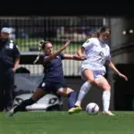 Seattle Reign FC midfielder Ainsley McCammon (left) and Racing Louisville FC forward Emma Sears (right) fight for possession of the ball during the second half at Lynn Family Stadium.