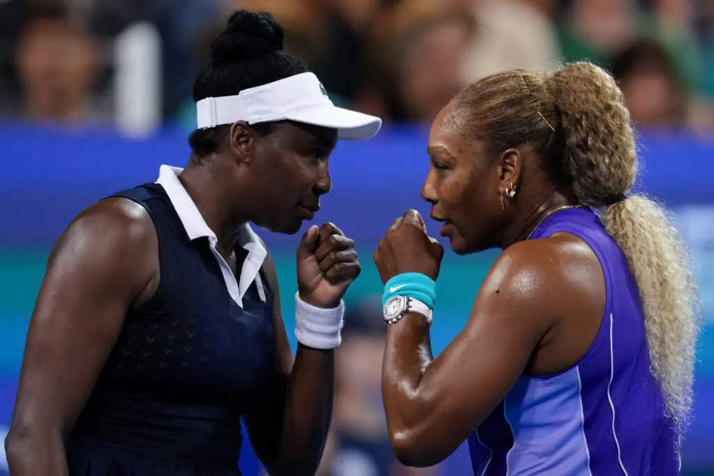 Serena Williams and Venus Williams of the United States talk after a point against Marta Kostyuk of Ukraine and Peyton Stearns of the United States in their doubles match during the Cincinnati Open at Lindner Family Tennis Center.