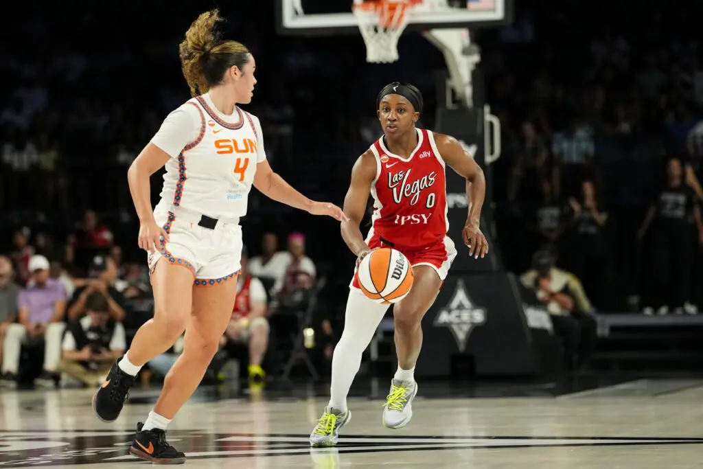 Las Vegas Aces guard Jackie Young (0) dribbles the ball against Connecticut Sun guard Charlisse Leger-Walker (4) during the second quarter of a WNBA basketball game at Michelob Ultra Arena.