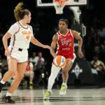 Las Vegas Aces guard Jackie Young (0) dribbles the ball against Connecticut Sun guard Charlisse Leger-Walker (4) during the second quarter of a WNBA basketball game at Michelob Ultra Arena.