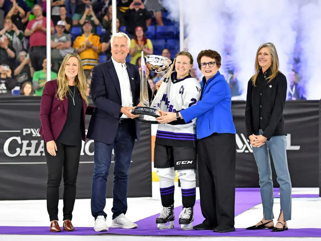 Kendall Coyne Schofield #26 of Minnesota receives the Walter Cup from Mark Walter and Billie Jean King, along with Kimbra Walter and Jayne Hefford during Game Five of the PWHL Finals.