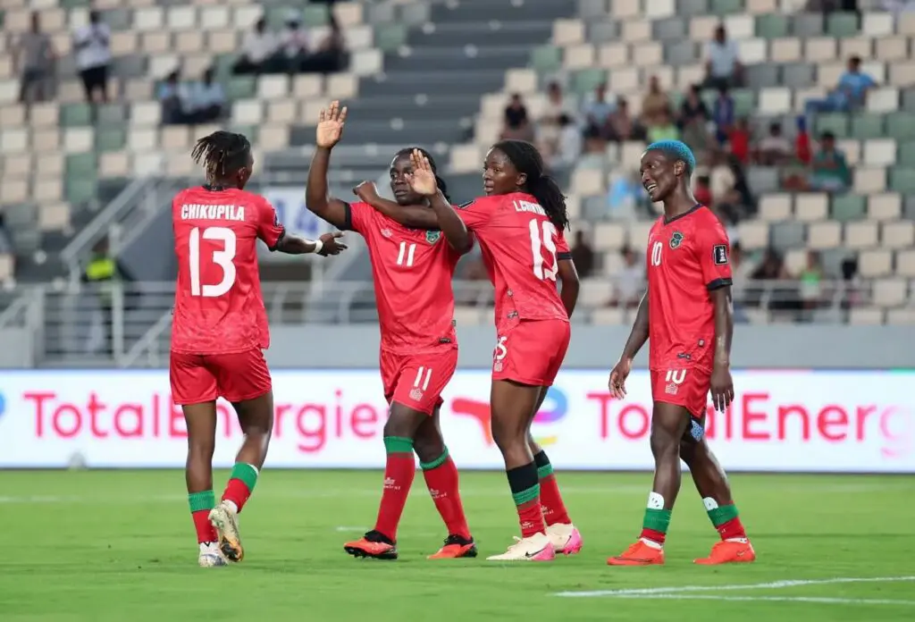 Malawi women’s national football team celebrates on the pitch after beating Algeria to make the 2026 WAFCON final.