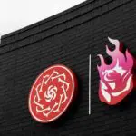 A black brick building with the Portland Thorns and Portland Fire logos sitting next to each other.