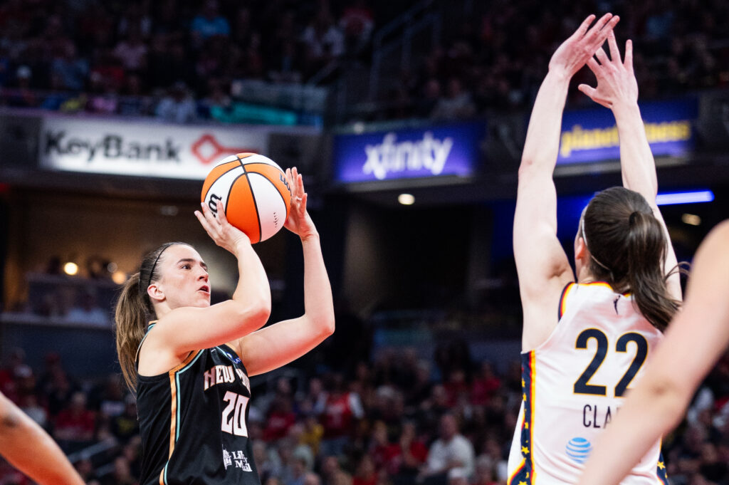New York Liberty guard Sabrina Ionescu (20) shoots the ball while Indiana Fever guard Caitlin Clark (22) defends in the first half at Gainbridge Fieldhouse.