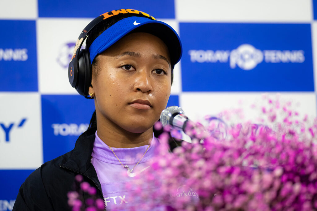Naomi Osaka stands at a microphone after a tennis match at the Toray Pan Pacific Open