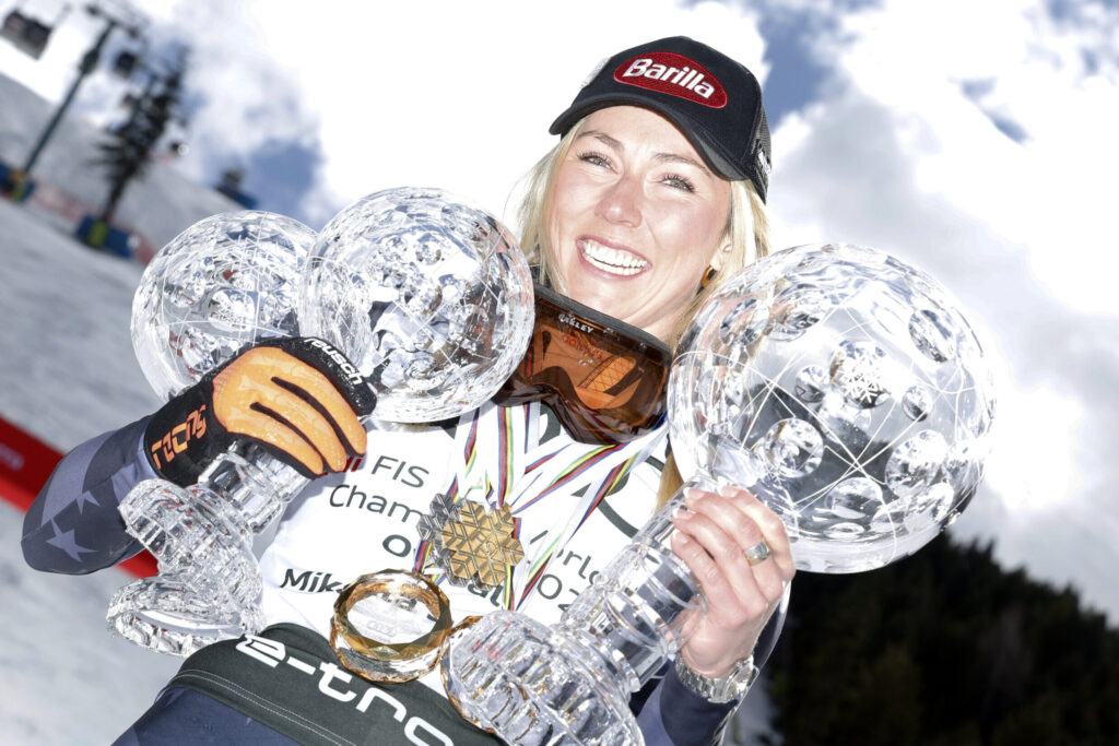Alpine skier Mikaela Shiffrin poses with her awards from the 2022-23 season.