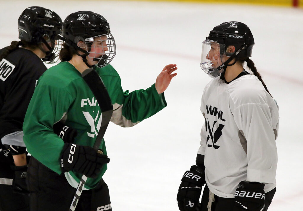 PWHL Boston's Emma Buckles chats with teammate Kaleigh Fratkin at practice. (John Tlumacki/The Boston Globe via Getty Images)