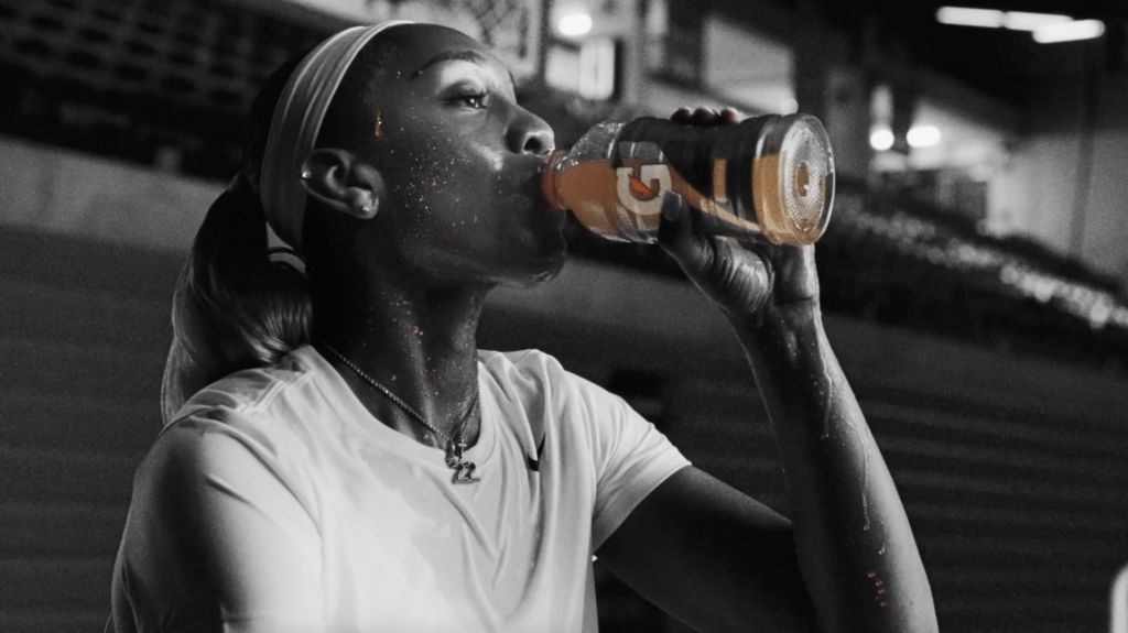 A'ja Wilson drinking a Gatorade in black and white, with orange Gatorade sweat
