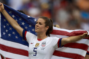 uswnt player kelley o'hara poses with an american flag at the world cup
