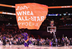 Phoenix Mercury mascot Scorch waving a 2024 WNBA All-Star flag at a 2023 home game.
