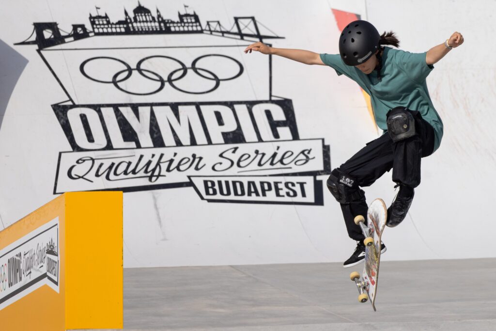 Japan's Coco Yoshizawa kick-flips her skateboard at the 2024 Olympic street qualifier