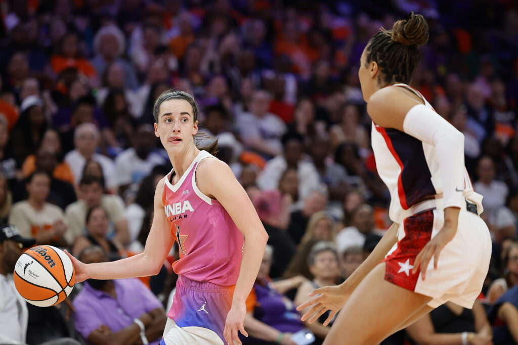 Team WNBA's Caitlin Clark passes around Team USA's Napheesa Collier at the 2024 All-Star Game