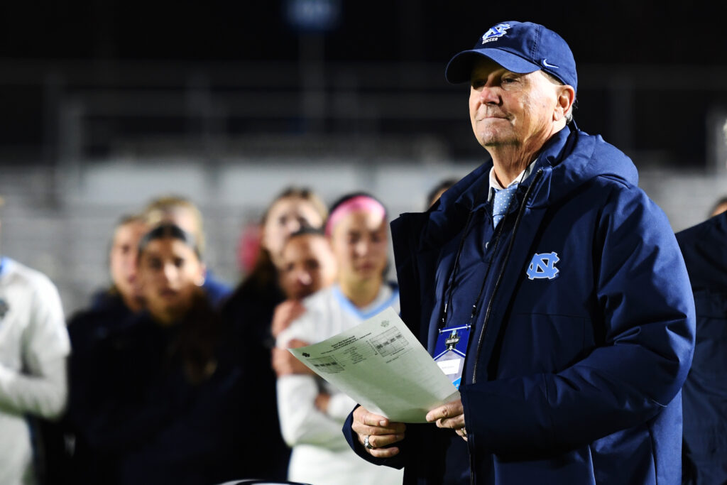 UNC soccer head coach Anson Dorrance stands on the 2022 NCAA championship match sideline.