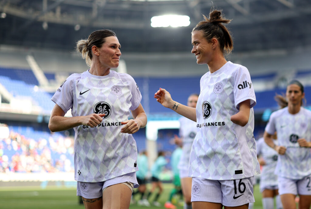 NWSL players Arin Wright and Carson Pickett on the field for Racing Louisville before Pickett's trade