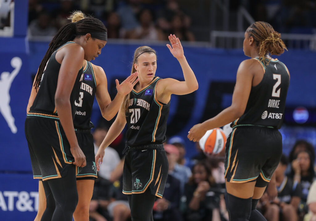 Sabrina Ionescu high-fives her Liberty teammates during a game.