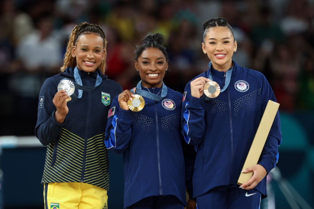 Gymnastics Silver medalist Rebeca Andrade of Brazil standing with Gold medalist Simone Biles and Bronze medal winner Suni Lee of USA Gymnastics