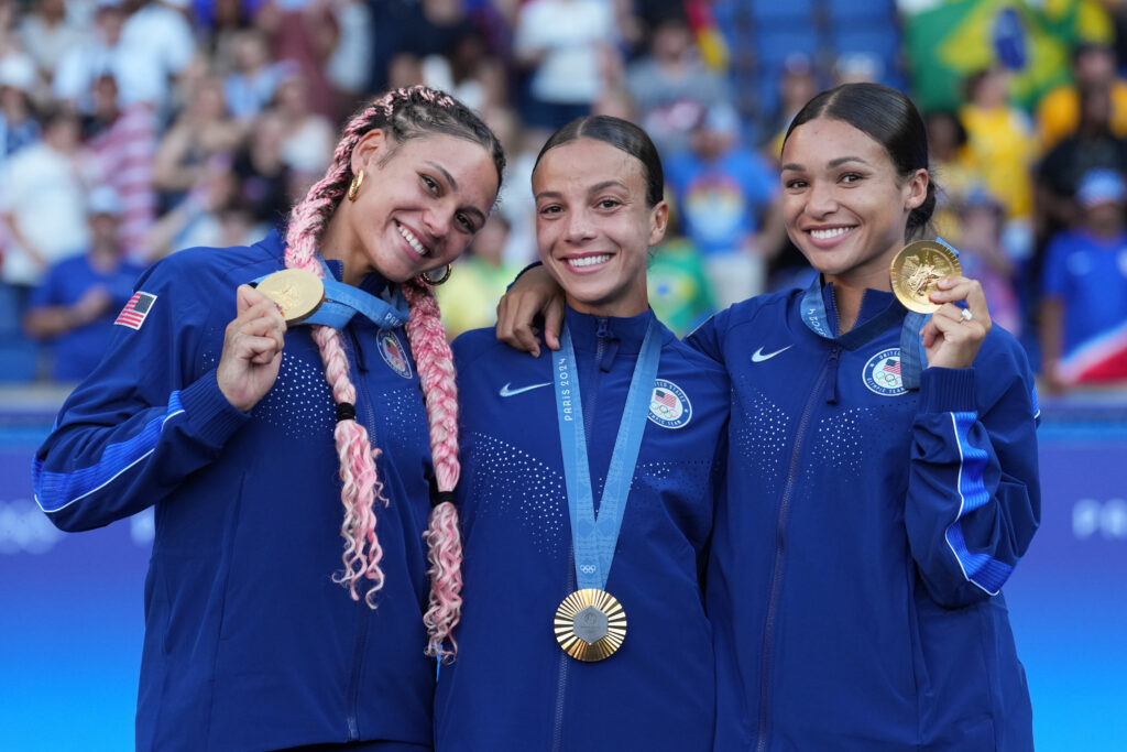 The USWNT front players consisting of Trinity Rodman, Mal Swanson and Sophia Smith show their Olympic gold medals.