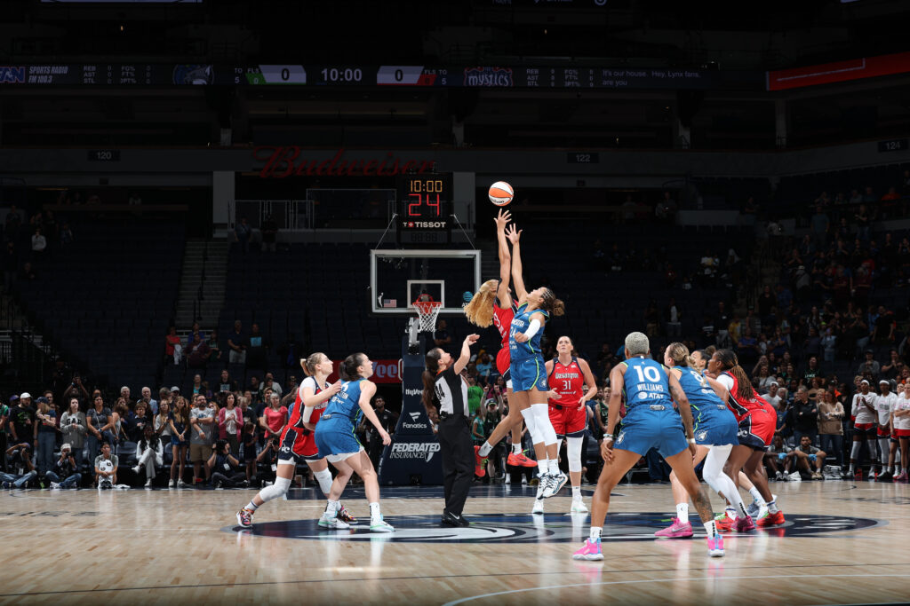 Washington's Shakira Austin and Minnesota's Napheesa Collier leap for the tip-off during their return to WNBA play