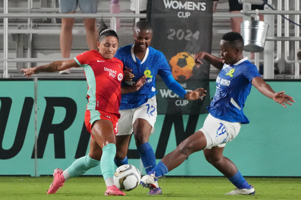 Debinha dribbles around two Mamelodi Sundowns defenders during their The Women's Cup semifinal