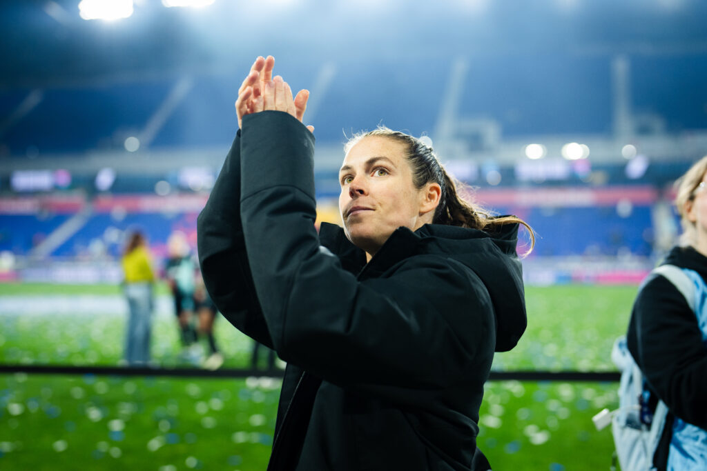 Gotham defender and Sports Are Fun! host Kelley O'Hara claps at the crowd after an NWSL match.