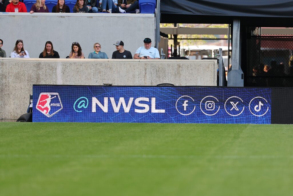 The NWSL logo appears on a field video board.