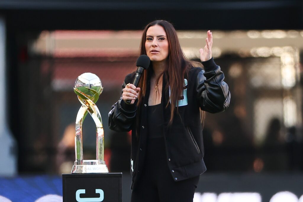 Standing next to Gotham's 023 NWSL Championship trophy, retired defender Ali Krieger speaks to a crowd.