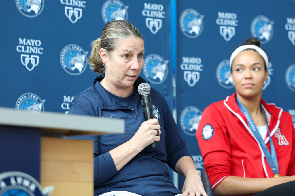 Minnesota coach Cheryl Reeve sits next to Napheesa Collier at a press conference.