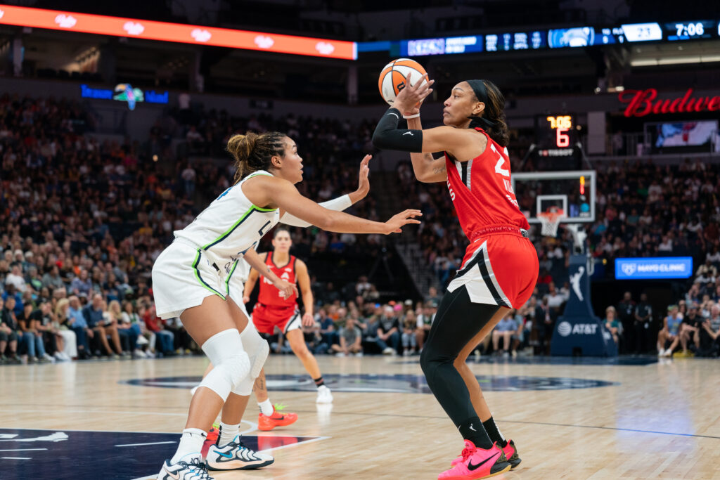 Aces center A'ja Wilson lines up a shot while Lynx forward Naphessa Collier defends.