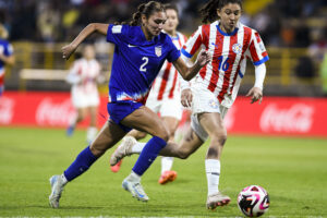 USYNT and ACFC defender races past Paraguay players with the ball on Saturday.