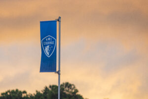 An NC Courage flag flies at sunset