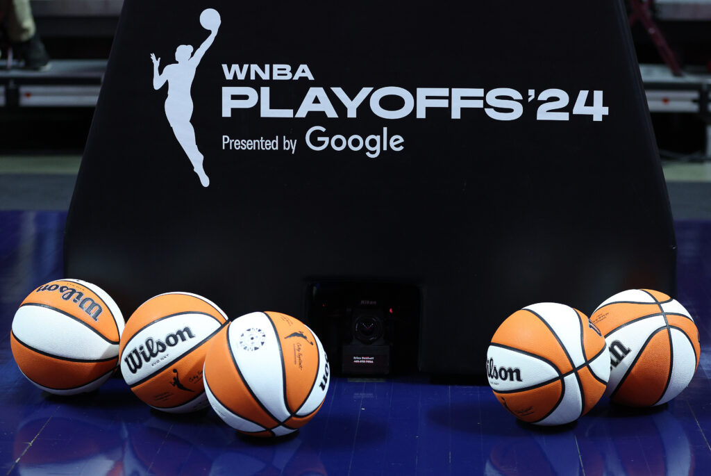 Basketballs sit in front of a stanchion emblazoned with the 2024 WNBA Playoffs logo.