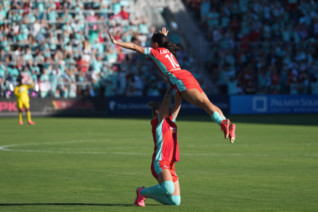 Kansas City defender Hallie Mace lifts midfielder Lo'eau LaBonta up, Dirty Dancing-style in a NWSL game.